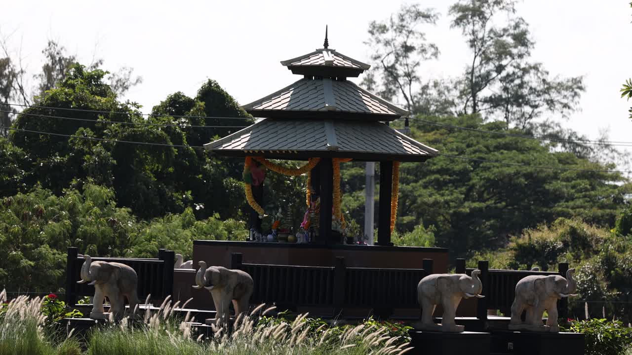 elefantes caminando por una estructura tradicional asiática