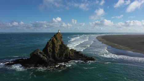 Flight-pass-Whatipu-Lighthouse-by-Huia-beach,-Huia-Reserve,-New-Zealand