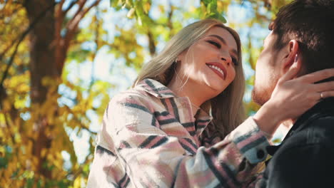 portrait of pretty young blonde woman in makeup with lipstick looking at boyfriend in the forest