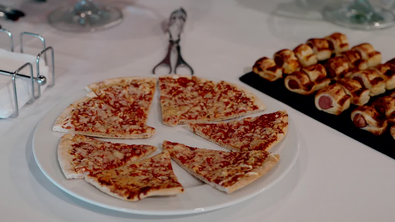 Mini pizzas and sausage rolls arranged for a casual party buffet table setup