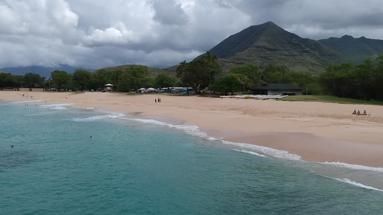 Riprese aeree RAW da drone di una spiaggia con le montagne a Oahu, Hawaii