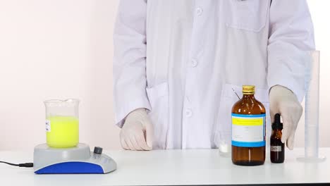 científico que agrega sustancias líquidas para realizar una reacción química de reloj de yodo