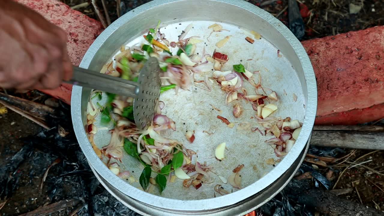 Curry leaves, onions, green chilies, ginger and garlic are saut&eacute;ed on fire ,black clam masala curry, traditional outdoor, black clams cooking, pollution , masala , brick