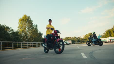 vista general del instructor del chico en una escuela de conducción en una camiseta amarilla. el conductor de la motocicleta hábilmente evita los obstáculos en forma de conos naranjas