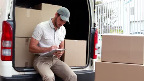 delivery driver checking his list on clipboard