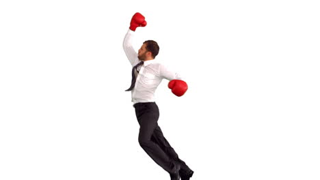 hombre de negocios con guantes de boxeo saltando y golpeando el aire