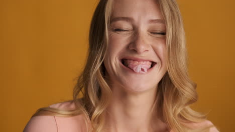 caucasian woman blowing bubblegum on camera.