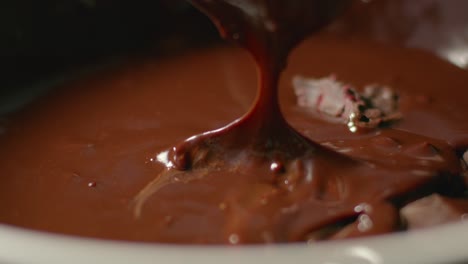 A-piece-of-dessert-is-dipped-into-melted-chocolate