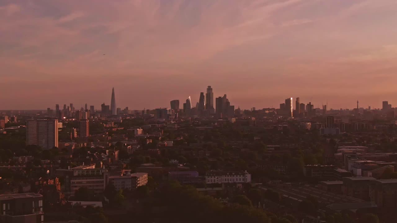 런던 해가 지는 드론이 도시를 향해 날아가고 있습니다.