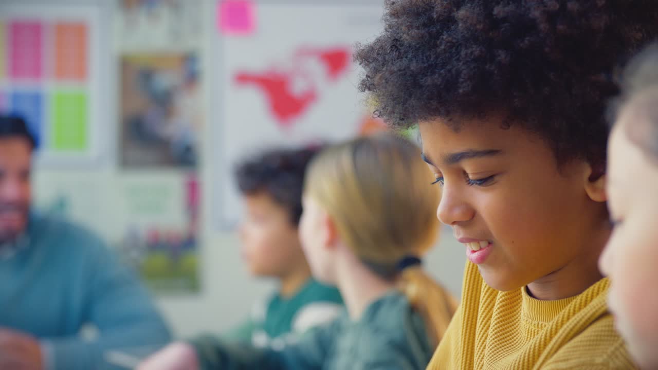 primer plano de estudiantes de escuela primaria y maestra usando tabletas digitales en la lección en el aula
