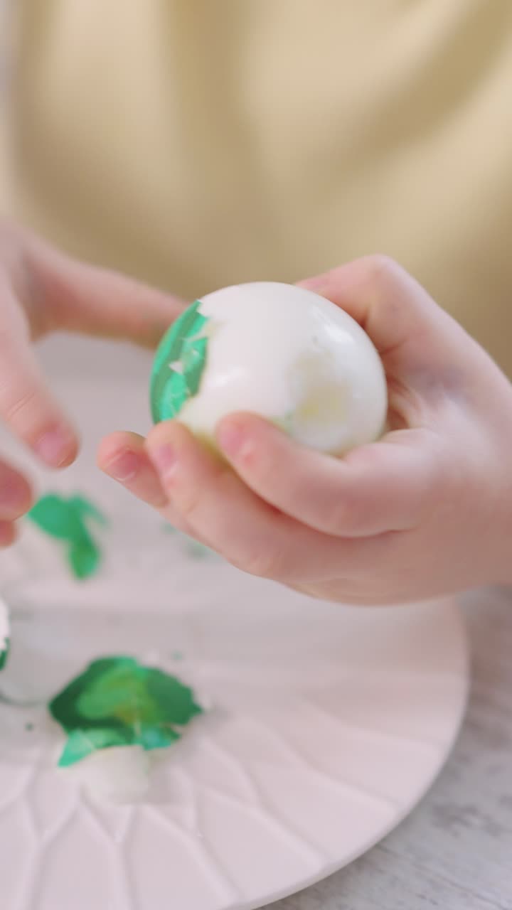Close-up of Child's Hands Peeling a Green Hard-Boiled Egg