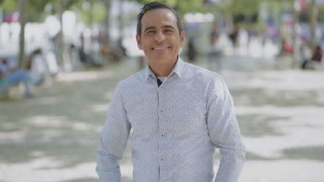 cheerful hispanic man looking at camera outdoor