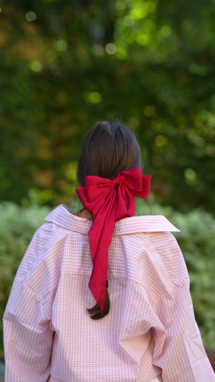 은 줄이 있는 분홍색 셔츠를 입은 여자