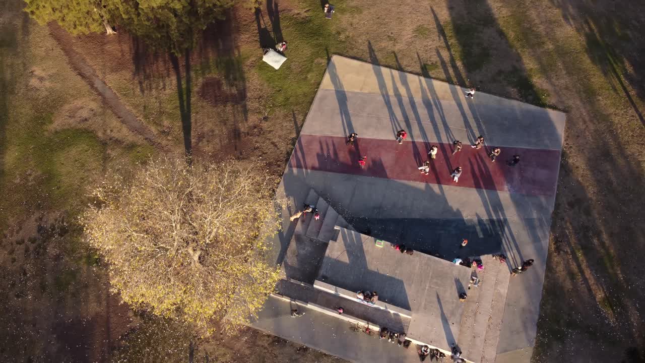 toma aérea de arriba hacia abajo de parejas bailando tango al aire libre en el parque al atardecer - buenos aires, argentina