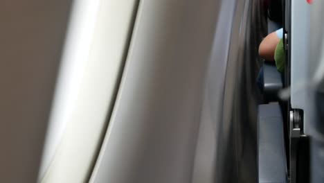 arm rest on armrest while sitting in airplane near window seat