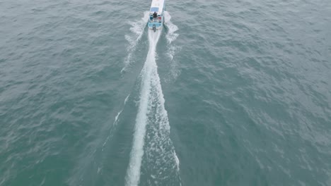 aerial footage catching up to and flying over a speedboat heading towards the shore on lake atitlan in guatemala