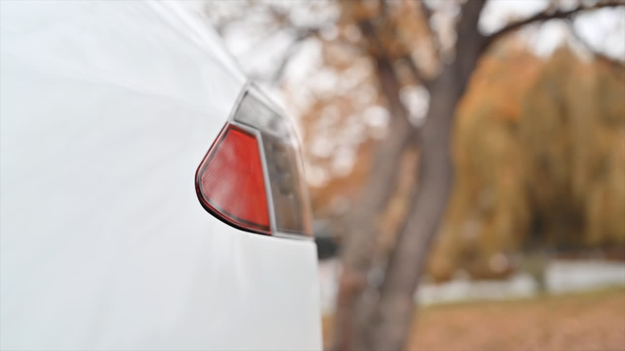 Slow motion close view of a man plugging charger into an electric car charging port
