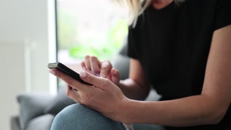 woman using a smartphone while sitting indoors