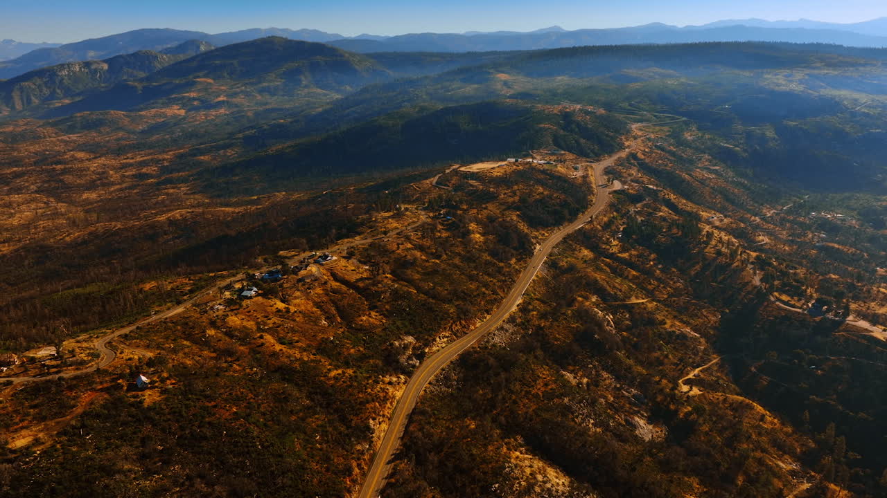 Few houses located on the bare rocks at Sierra National Forest, USA. Amazing rocky landscape at backdrop. Aerial perspective.