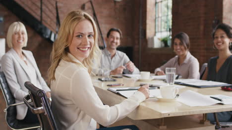 Retrato-De-Una-Joven-Mujer-De-Negocios-Segura-De-Sí-Misma-En-La-Mesa-De-La-Sala-De-Juntas-En-Cámara-Lenta-Dándose-La-Vuelta-Y-Sonriendo