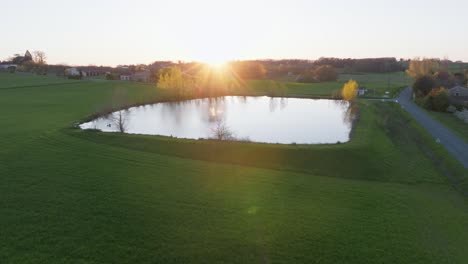 Drone-Cinematográfico-Filmado-De-Bajo-A-Alto-Sobre-Un-Lago-Claro-Durante-La-Puesta-De-Sol