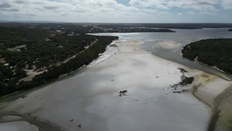 Toma-Cinematográfica-Del-Agua-Del-Río-Fusionándose-Con-El-Agua-Del-Océano,-Australia