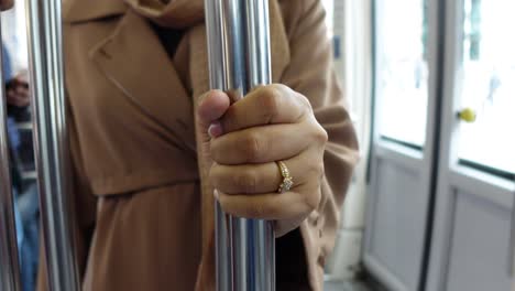 woman holding onto a metal pole on public transport