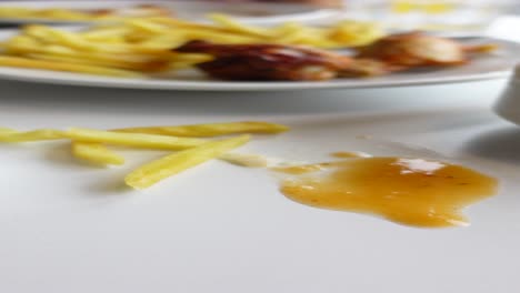 plato vacío con alas de pollo y papas fritas sobrantes