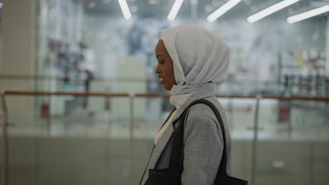 happy african-american lady with hijab in shopping mall