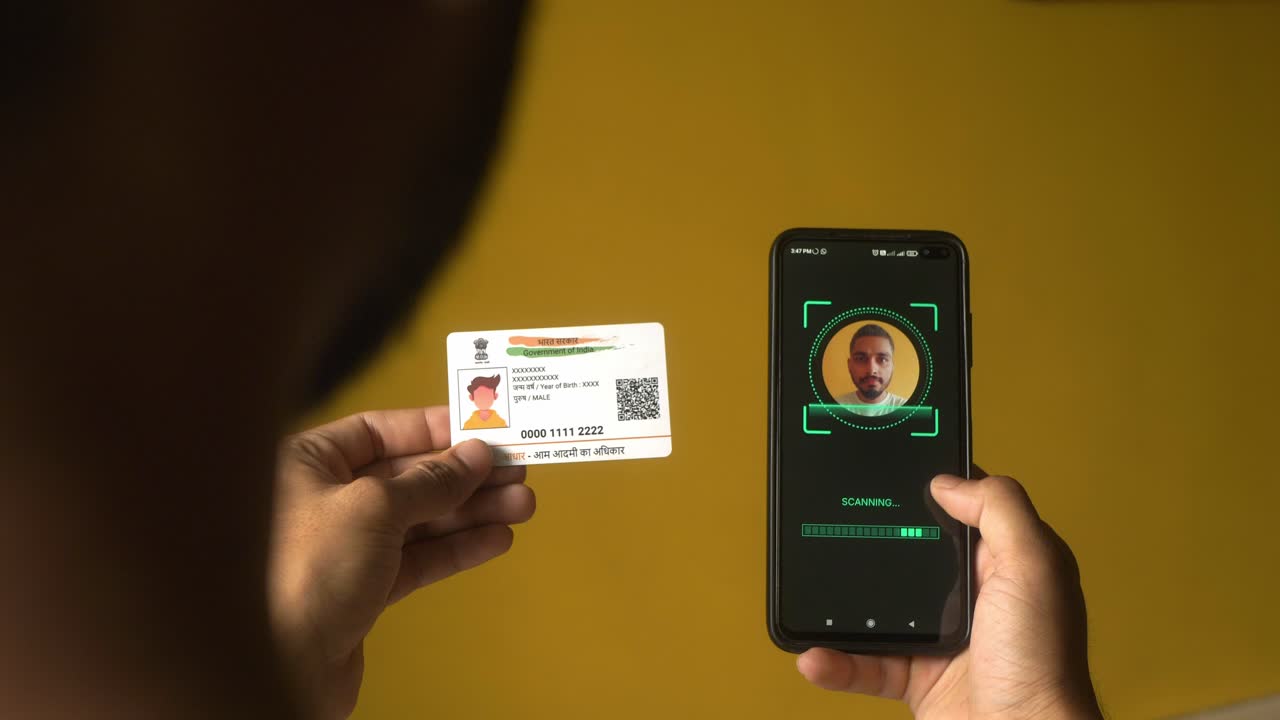 Indian nationality man scanning his face on mobile phone for eKYC digital identity verification using Aadhaar card