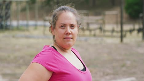 mujer caucásica mirando a la cámara en el campo de entrenamiento