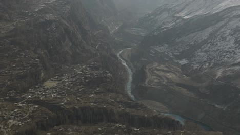 high angle aerial surveillance drone view of hunza valley with river running through valley