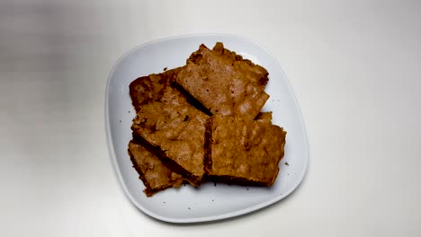 mano de mujer tomando un brownie para darle un mordisco y dejándolo atrás