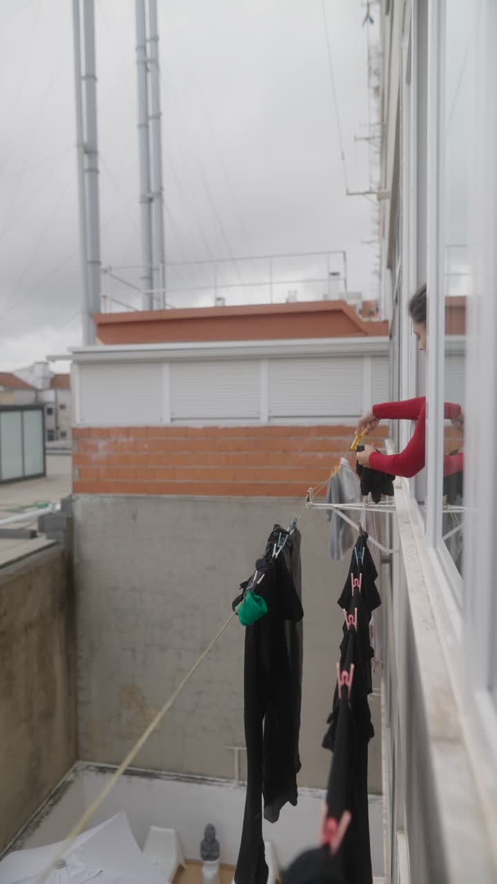 Woman doing laundry on a balcony