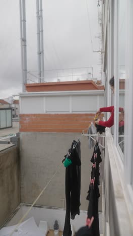 woman doing laundry on a balcony