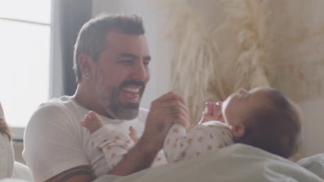 Happy-Father-Laughing-And-Playing-With-Little-Daughter-In-Bed-On-Sunday-Morning