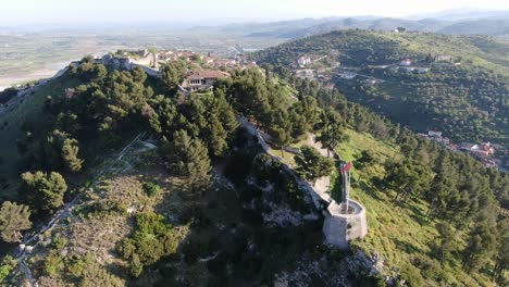 drone view in albania flying in berat town over a medieval castle on high ground fort showing the brick brown roof houses from top