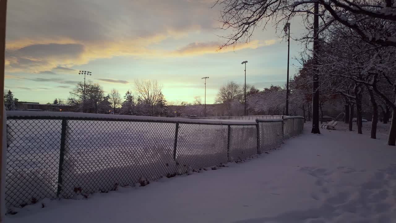 Snow-covered Lafond Park With Chain-link Fence During Sunset In Montreal, Canada. - POV shot