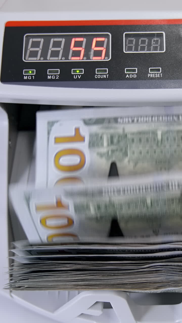 Automatic money counting in the machine. Electronic money machine is counting the dollar banknotes. Front view. Close-up. Vertical video
