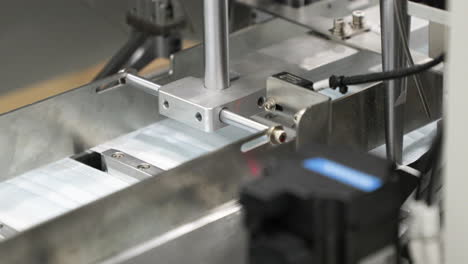 máscara médica en la línea de producción - colocación de orejeras en maquinaria automatizada - toma de primer plano