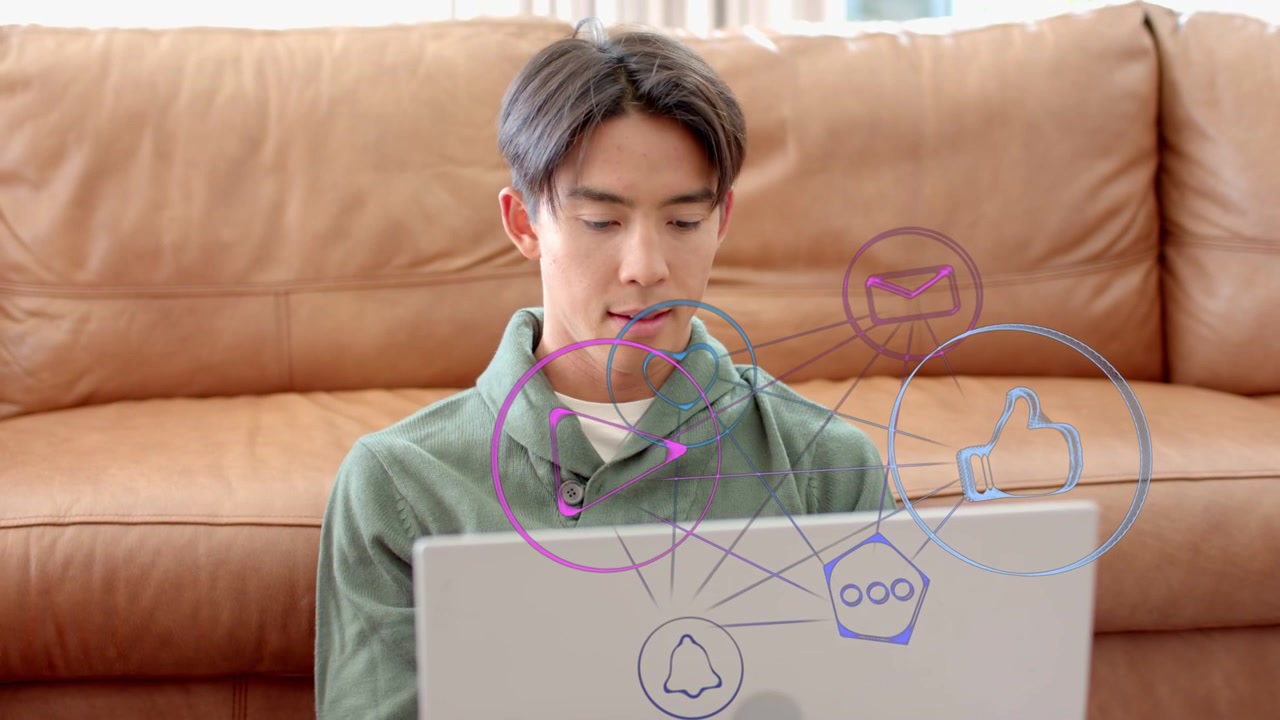 Uomo che posiziona il laptop sulle ginocchia e attiva icone social animate mentre tocca lo schermo, interagendo con i social media.