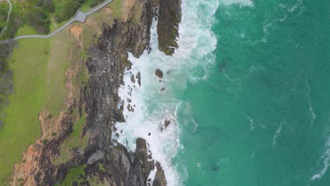 waves crash against rocky cliffs at byron bay