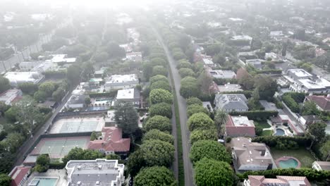 Beverly-Hills-Neighborhood,-early-morning-fog-over-homes,-aerial-view