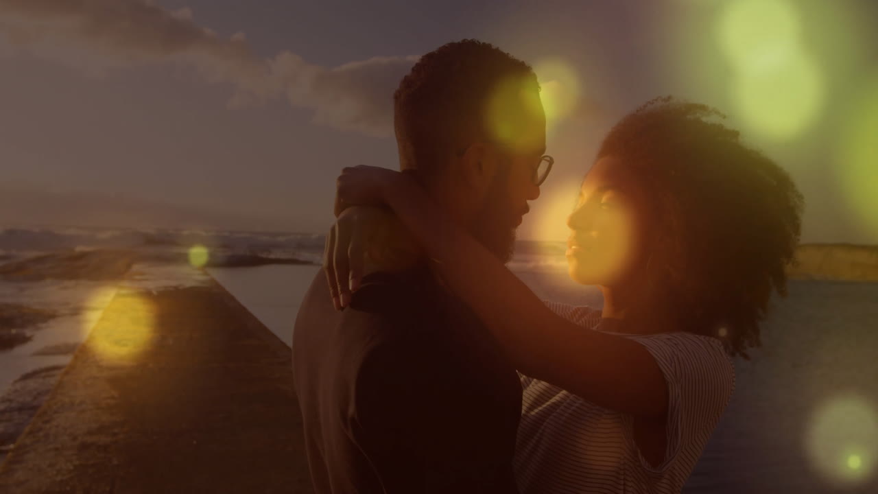 바가에서 안고 있는 두 인종의 커플에 대한 빛의 반점 애니메이션