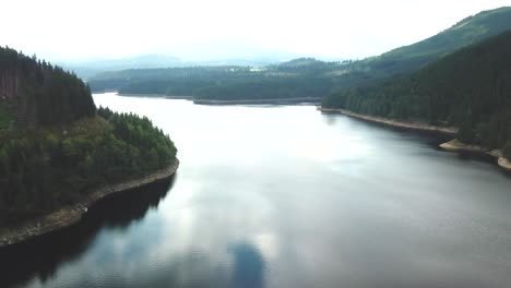 Forward-drone-shot-over-a-lake-with-clouds-reflected-on-it