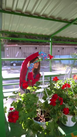 mujer regando flores en un centro de jardín