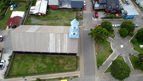 aerial drone rotate above patrimonial chilean church in dalcahue chiloé island around streets and local neighborhood