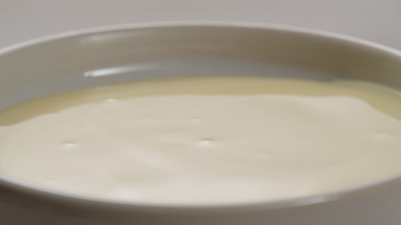 saborosa leche condensada, cuchara y waffles en la mesa gris claro, plana. espacio para el texto. imágenes de alta calidad 4k