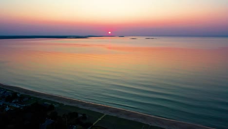 Puesta-De-Sol-Sobre-Casas-De-Playa-Con-Coloridos-Reflejos-De-Las-Olas-Del-Océano-Y-Casas-De-Vacaciones-A-Lo-Largo-De-La-Costa-Atlántica-De-Nueva-Inglaterra