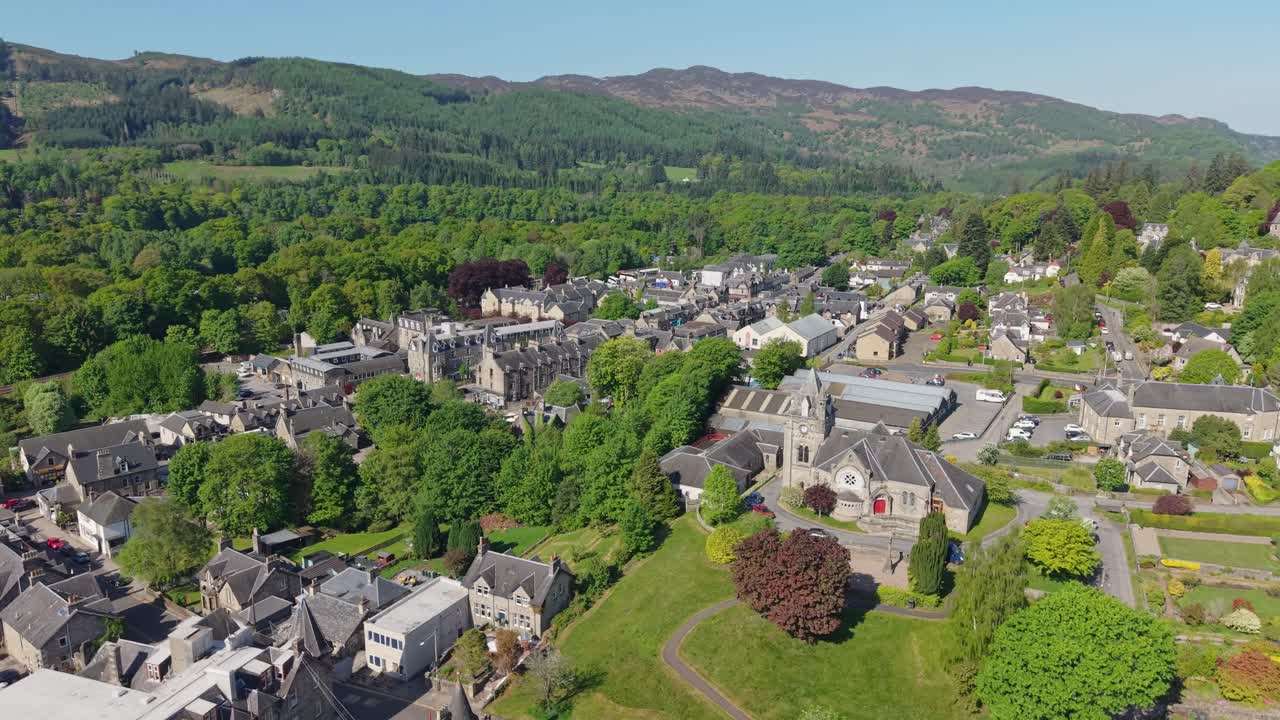Orbiting Pitlochry village nestled in a green valley, showcasing scenic landscapes, historic architecture, and the charming Scottish countryside